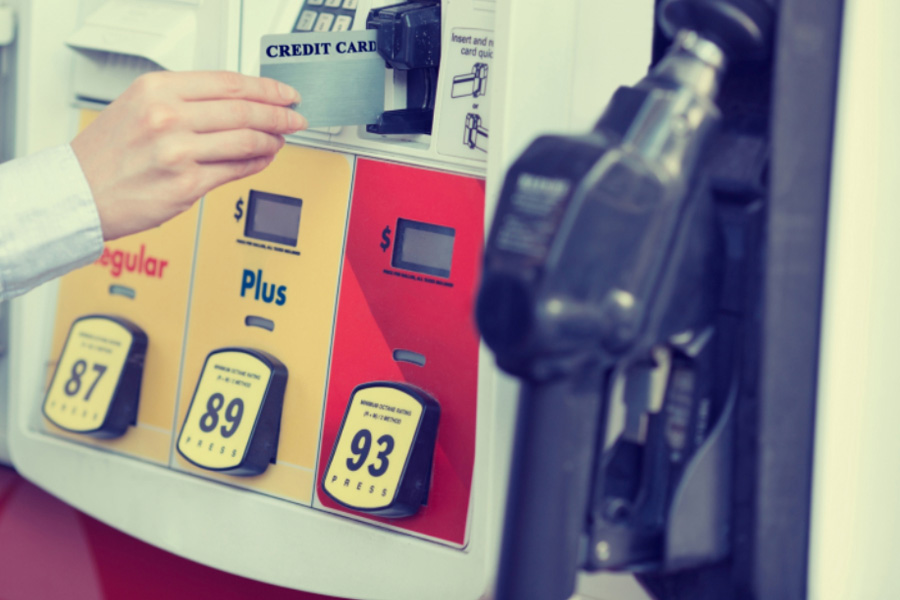 A person using a credit card at a gas pump