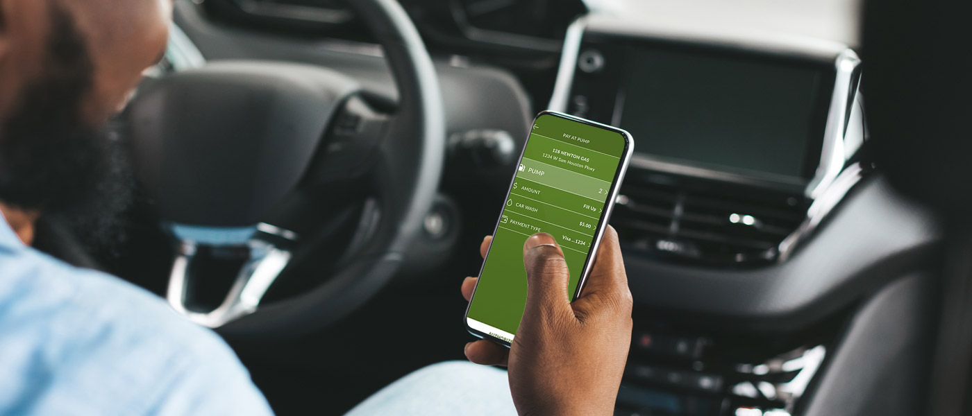 man in car using the Fuelco.com App to pay for his gas