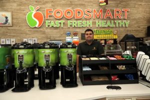 Owner of FOODSMART standing behind the coffee and tea station.